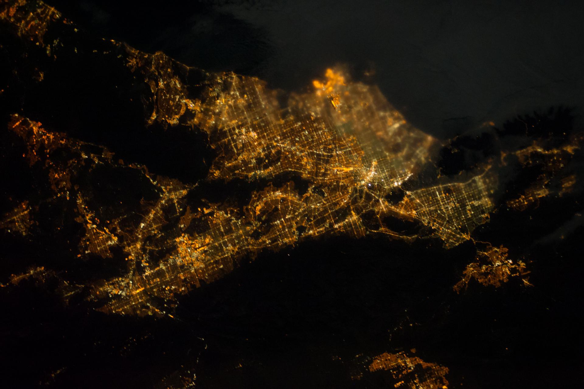 Earth at night from orbit, city lights across the dark