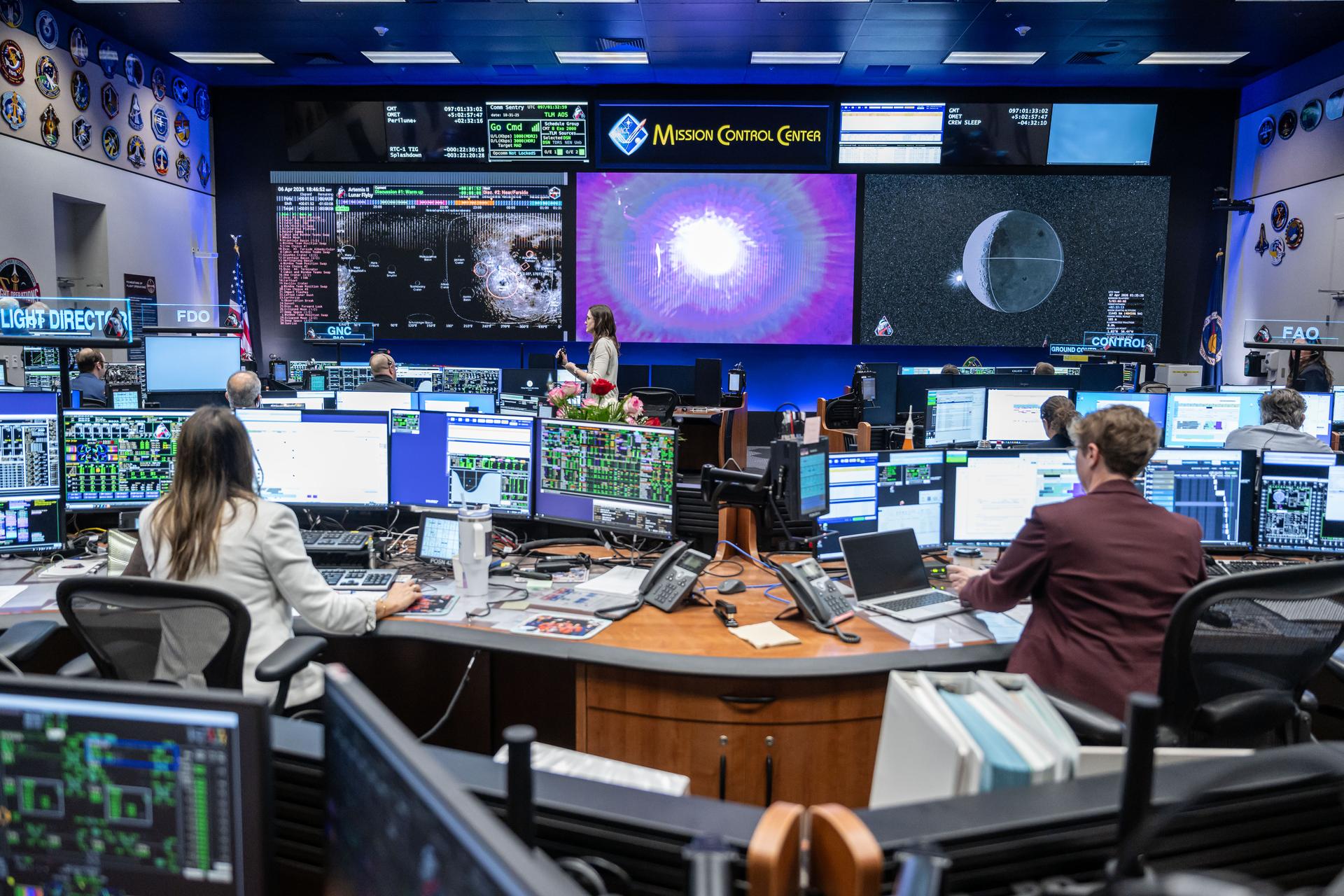 Rows of flight-controller consoles in a NASA mission control room
